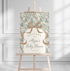 an easel with a welcome baby shower sign on it in front of a white wall