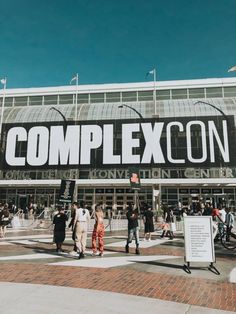 people walking in front of a complexcon building