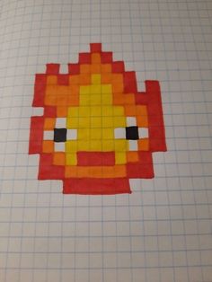 an orange and yellow fish made out of paper on top of a sheet of graph paper