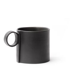 a black coffee mug sitting on top of a white table