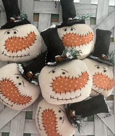 four snowmen are sitting on top of each other with black hats and orange noses