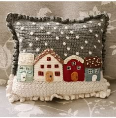 a crocheted pillow with houses on it