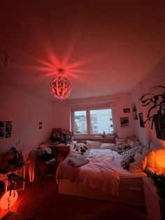 a bed room with a neatly made bed and a chandelier hanging from the ceiling