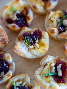 small appetizers with cranberry sauce and nuts are arranged on a wooden surface