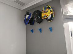 several helmets are hanging on the wall next to each other in a room with gray walls