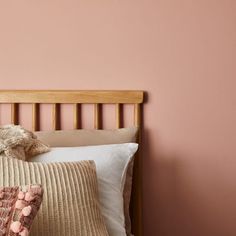 a teddy bear sitting on top of a bed next to two pillows and a pillow case