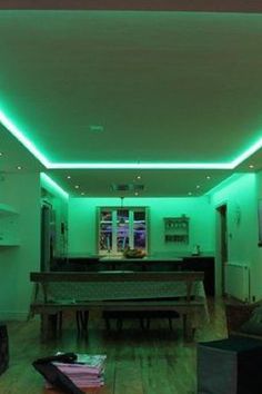 a living room filled with furniture and green lights on the ceiling, along with a piano