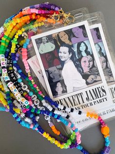 a stack of colorful bracelets sitting on top of a table next to a magazine