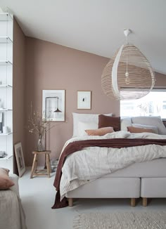 a bed sitting in a bedroom next to a white shelf filled with pictures and pillows