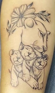 a woman's leg with a tattoo on it that has an image of a lion and two cubs