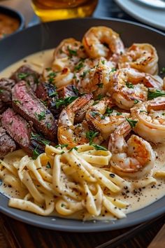 a plate of pasta with shrimp and steak