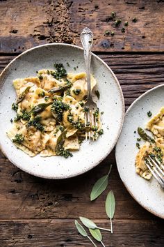 two plates with pasta and broccoli on them, one has a fork in it