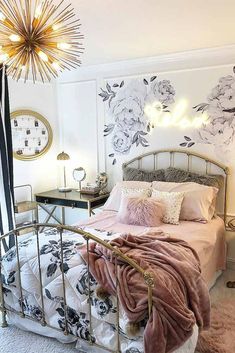 a bedroom with a metal bed frame and floral wallpaper on the walls, along with a chandelier