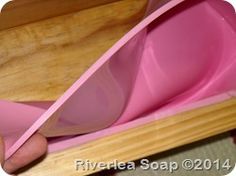 a pink bowl with wooden spoons in it