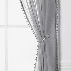 a curtain with pom - poms hanging on it's side in front of a window