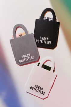 three small luggage tags with the words urban outfitters on them