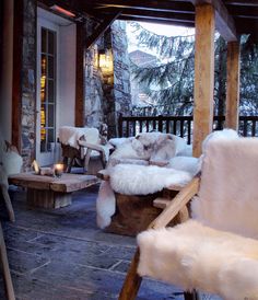 the porch is covered with white fur and wood furniture