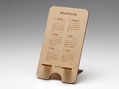 a wooden desk calendar on a stand with the date marked one - make in black ink