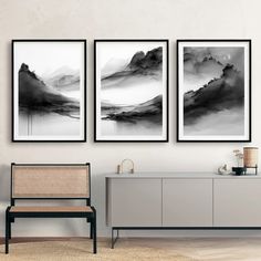 three black and white paintings hanging on the wall next to a sideboard in a living room