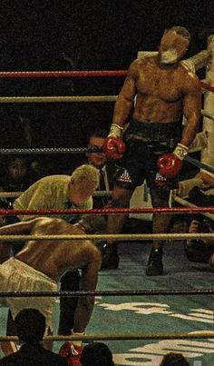 two men standing next to each other in a ring with boxing gloves on their heads