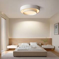 a bed room with a neatly made bed and a ceiling light over the headboard