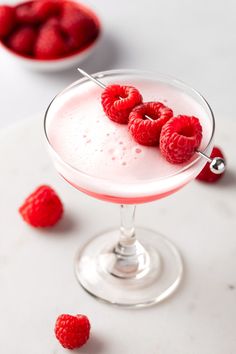 raspberries are placed on the rim of a drink