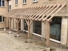 an outside view of a building with a covered patio area and wooden pergols