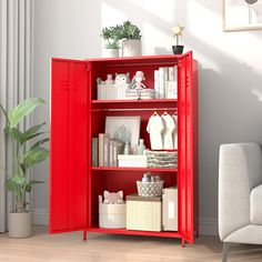 a red bookcase filled with lots of items next to a white chair and potted plant