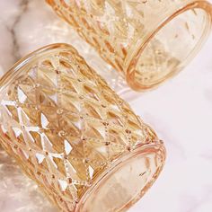 two glass cups sitting on top of a marble counter