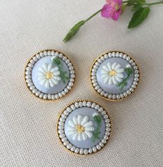 three small white flowers are sitting on a table