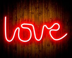 a red neon sign that says love on a wooden wall