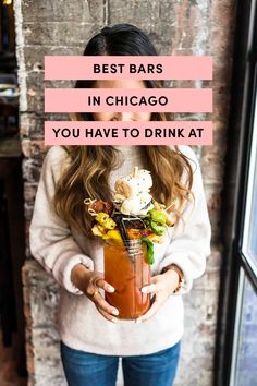 a woman holding a drink with the words best bars in chicago you have to drink at