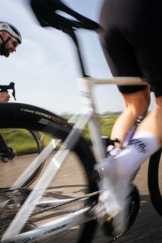 a blurry photo of two people riding bikes on the road with one person holding his bike