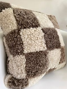 a brown and white pillow sitting on top of a chair