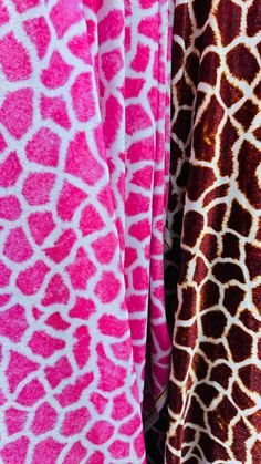 two giraffe print shirts hanging on a clothes line, one in pink and the other in brown