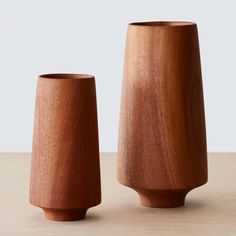 two wooden vases sitting next to each other on a table