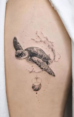 a black and white photo of a turtle on the back of a woman's thigh