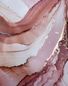 pink and white marble with gold veining on the edges is shown in close up