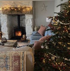 a living room filled with furniture and a christmas tree in front of a fire place