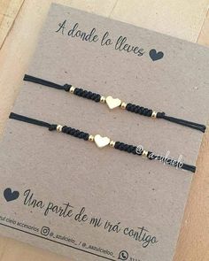 two black and gold bracelets with heart charms on each one, in front of a card