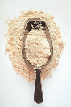 a spoon full of flour sitting on top of a table