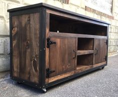 an entertainment center made out of wood with metal handles and doors on the outside wall