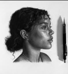 a pencil drawing of a woman's face next to a pen