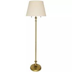 a gold floor lamp with a white shade on the base and a light bulb at the end