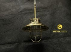 an antique brass hanging light fixture on a black background with the words nautica properties