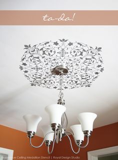 a chandelier hanging from the ceiling in a room with an ornate design on it