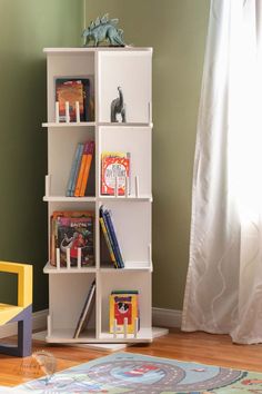 a white book shelf with books on it in a child's room next to a yellow chair