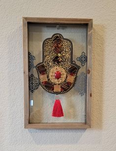 a hamsa hanging on the wall with a red tassel