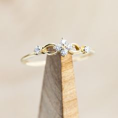 a diamond ring sitting on top of a wooden stand