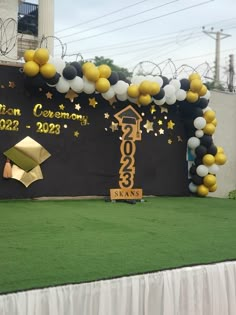 an outdoor stage decorated with balloons and stars for graduation ceremony in front of a building